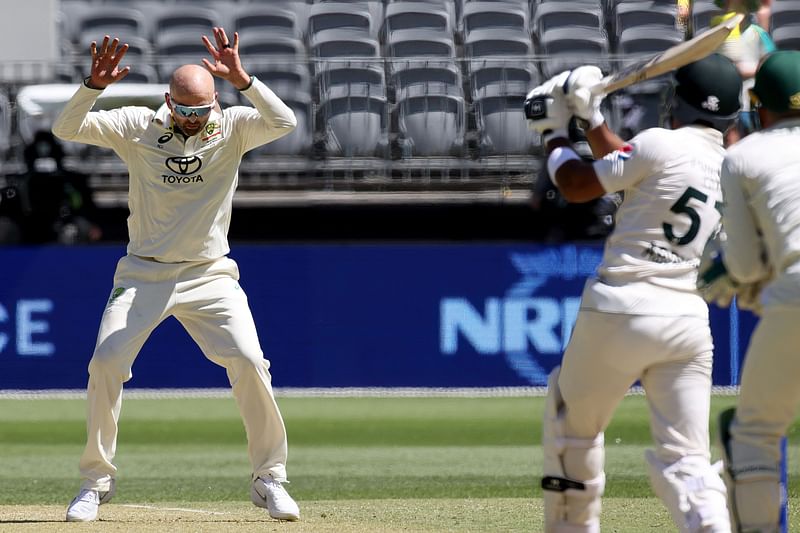 Australia's Nathan Lyon bowls and moves out of the way from Pakistan's Abdullah Shafique's shot during the second day of the first Test cricket match between Australia and Pakistan in Perth on 15 December, 2023