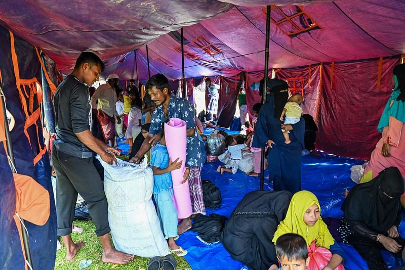 Rohingya refugees prepare to relocate after nearby villagers pushed back against their camp's presence in Balohan on Sabang island, Indonesia's Aceh province on 4 December, 2023