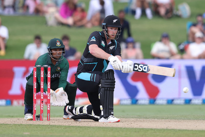 New Zealand’s James Neesham  plays a shot in front of Bangladesh’s wicketkeeper Rony Talukdar during the third Twenty20 cricket match between New Zealand and Bangladesh at Bay Oval in Mount Maunganui on 31 December, 2023.