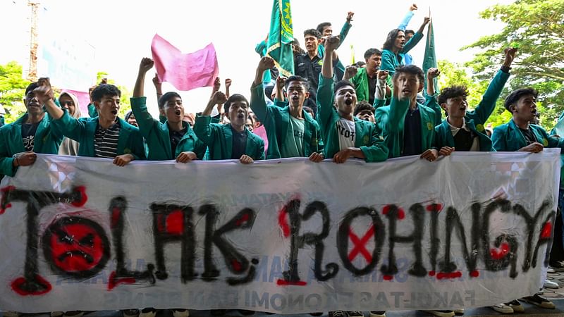 University students hold a banner that reads “reject the Rohingya” as they demonstrate against the arrival of Rohingya refugees in front of the People’s Representative Council (DPR) in Banda Aceh on 27 December, 2023