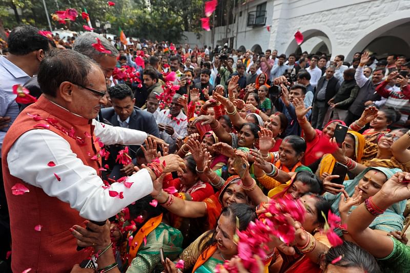 Chief Minister of Madhya Pradesh and member of Bharatiya Janata Party (BJP) Shivraj Singh Chouhan (2L) is greeted by his supporters at his residence in Bhopal on 3 December, 2023, following BJP's victory at the Madhya Pradesh assembly elections.