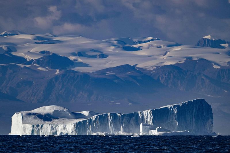 This photograph taken on 16 August, 2023, shows an iceberg, approximately a few hundred metres long, drifting along the Scoresby Sound Fjord, in Eastern Greenland.