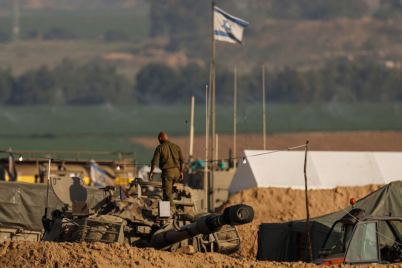 An Israeli solider walks on a mobile artillery unit, amid the ongoing conflict between Israel and the Palestinian Islamist group Hamas, near the Israel-Gaza border in southern Israel, 20 January, 2024