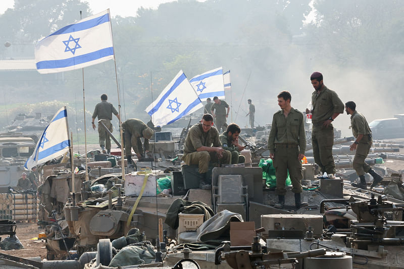 Israeli soldiers stand on tanks, amid the ongoing conflict between Israel and the Palestinian Islamist group Hamas, near the Israel-Gaza border, in southern Israel, 1 January, 2024