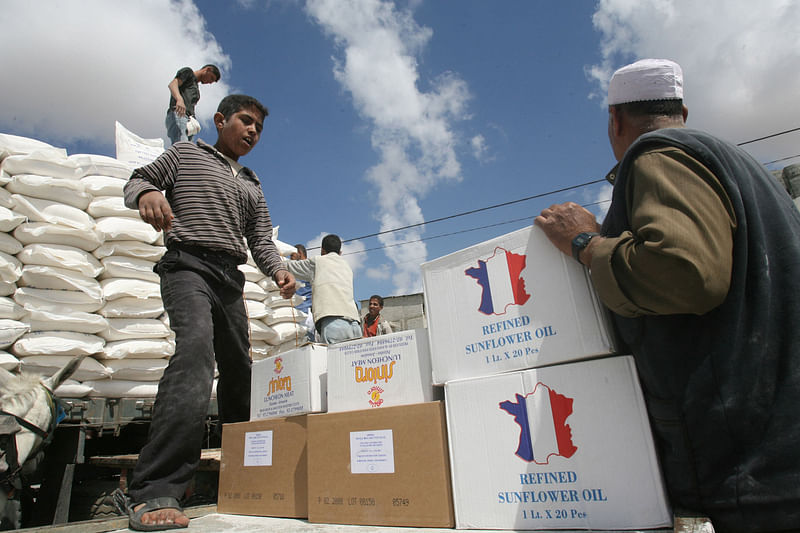 Palestinian refugees carry food aid they received from the United Nations Relief and Works Agency for Palestine Refugees (UNRWA) on April 24, 2008 in Rafah, southern Gaza Strip.