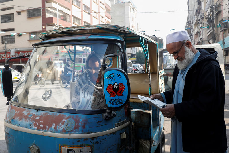 Men read newspapers, after the Pakistani foreign ministry said the country conducted strikes targeting separatist militants inside Iran, along a road in Karachi, Pakistan on 18 January, 2024