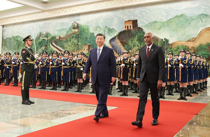 The photo taken on 10 January, 2024 shows Maldives’ President Mohamed Muizzu (R) and Chinese President Xi Jinping walking during a welcome ceremony at the Great Hall of the People in Beijing