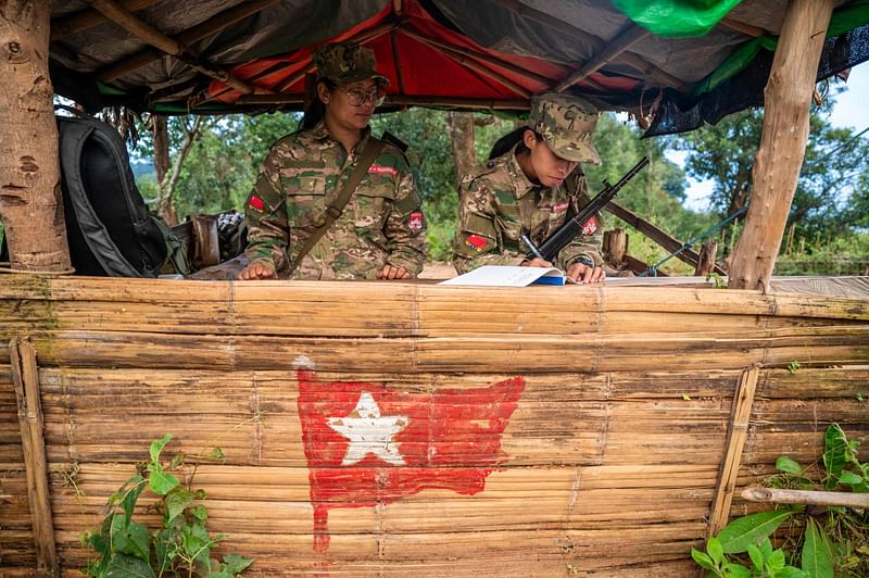 This photo taken on 9 December, 2023 shows female members of the Mandalay People’s Defense Forces (MDY-PDF) standing guard at their base camp in the forest near Namhsan Township in Myanmar's northern Shan State