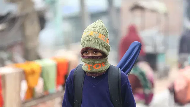 A student is on the way to school amid bitter cold in the morning at Chelopara, Bogura, on 15 January in 2024