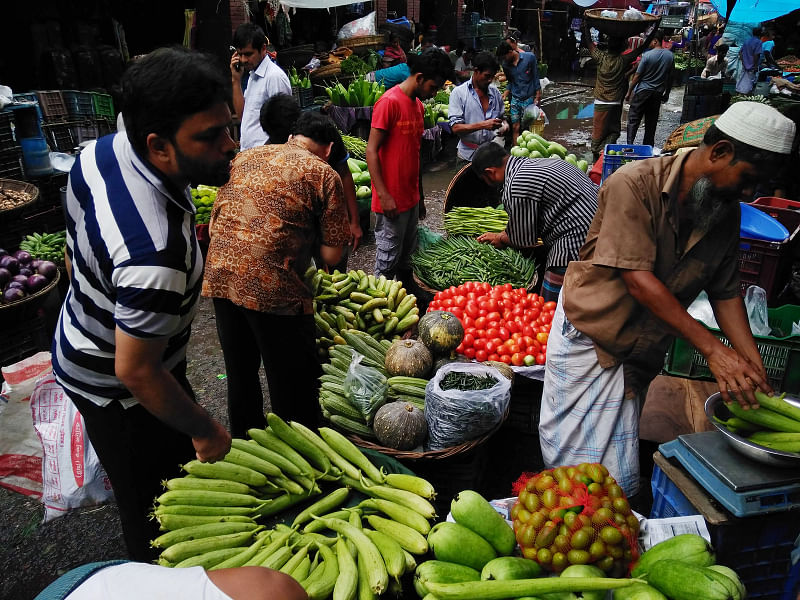 A customer purchases vegetables at Karwan Bazar kitchen market, Dhaka.