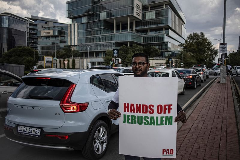 A pro Palestinian activist holds a banner as he demonstrates following the International Court of Justice (ICJ) ruling of the case against Israel brought by South Africa in The Hague at the US Consulate in Johannesburg on 26 January, 2024