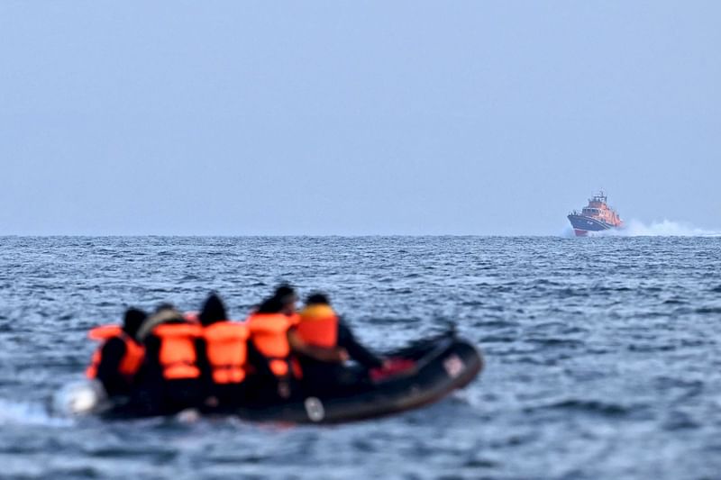 Royal National Lifeboat Institution (RNLI) Severn class lifeboat, the City of London II, makes its way towards migrants travelling in an inflatable boat across the English Channel, bound for Dover on the south coast of England