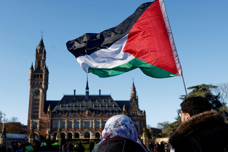 Protesters hold a Palestinian flag as they gather outside the International Court of Justice (ICJ) as judges rule on emergency measures against Israel following accusations by South Africa that the Israeli military operation in Gaza is a state-led genocide, in The Hague, Netherlands, 26 January, 2024.