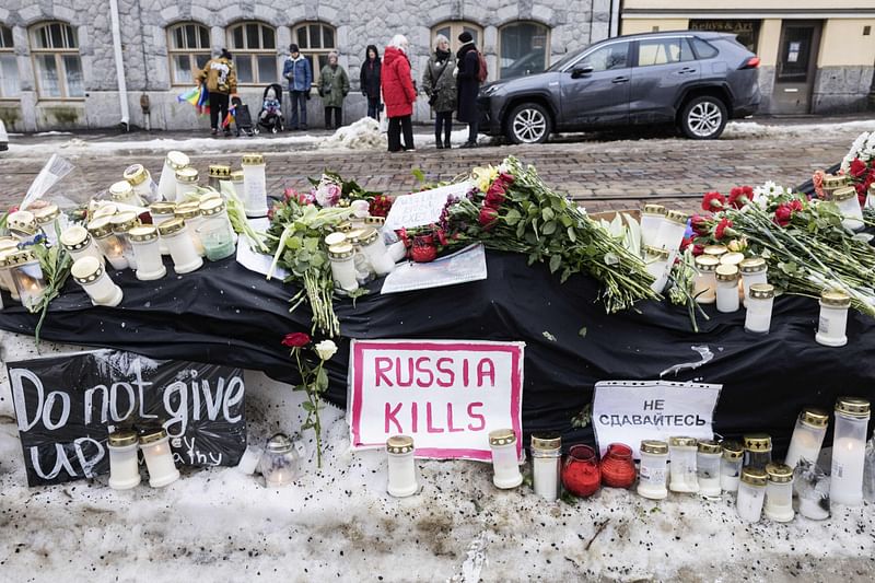 People place flowers and candles in front of the Russian embassy in Helsinki, Finland on February 17, 2024, one day after Russian officials announced the death of the Kremlin's most prominent critic Alexei Navalny.