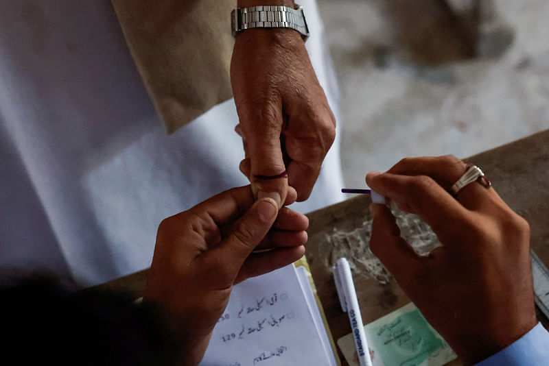 A voter gets an ink mark on his thumb after casting his vote during the general election in Karachi, Pakistan 8 February, 2024.