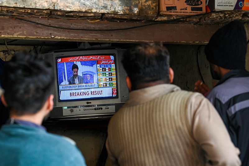 People monitor latest election results live on a television at a tea shop, a day after Pakistan’s national elections in Lahore on 9 February, 2024