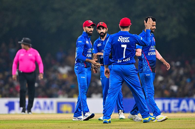 Afghanistan's Ibrahim Zadran (L) celebrates with teammates after their victory by 3 runs in the third and final Twenty20 international cricket match between Afghanistan and Sri Lanka at The Rangiri Dambulla International Cricket Stadium in Dambulla on 21 February, 2024