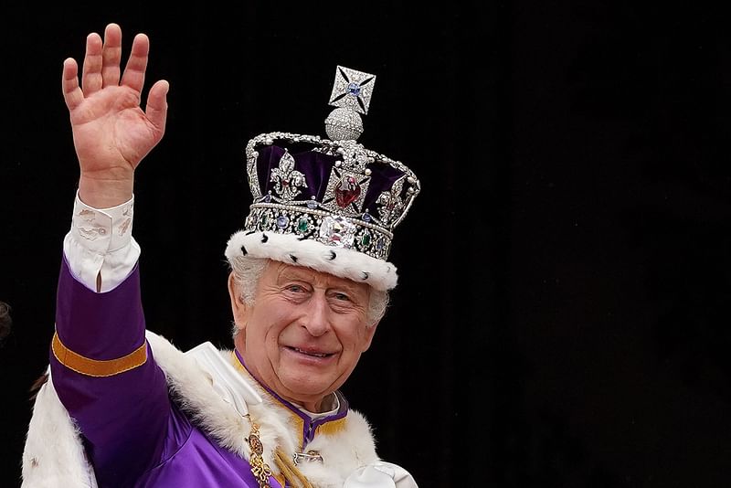 Britain's King Charles III wearing the Imperial state Crown, waves from the Buckingham Palace balcony after viewing the Royal Air Force fly-past in central London on May 6, 2023, after his coronation.