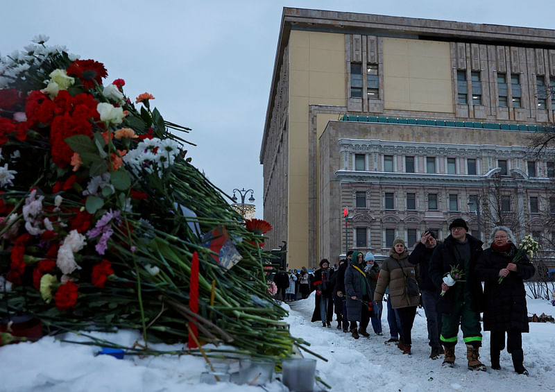 People walk to lay flowers at the Solovetsky Stone monument to the victims of political repressions to honour the memory of Russian opposition leader Alexei Navalny in Moscow, Russia February 17, 2024