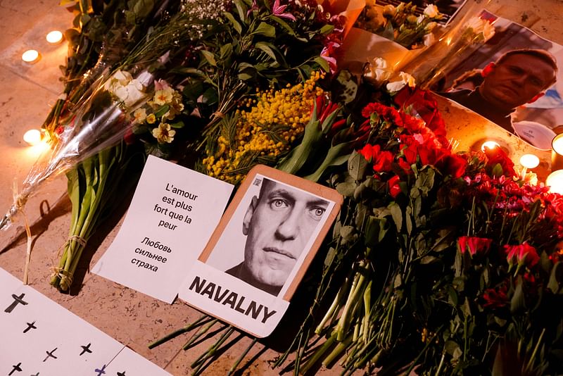 This photograph taken on 17 February, 2024, shows portrait placards, flowers and candles displayed as part of a tribute rally to Alexei Navalny, following the announcement that the Kremlin's critic had died in an Arctic prison, at Place du Trocadero in Paris