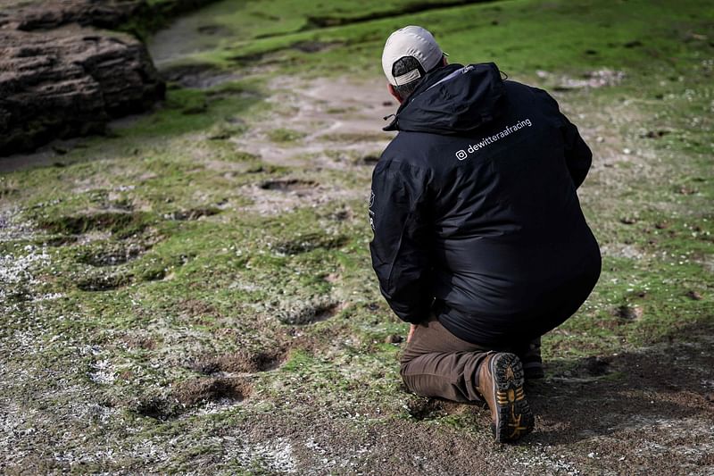 A man examines a set of ancient footprints, believed to have been left by anatomically modern humans (Homo Sapiens) and to be dating to more than 100,000 years ago, discovered along the coast in the Larache region, about 90 kilometres (55 miles) south of Tangier, in northern Morocco on 5 February, 2024. Archaeologists in Morocco have unearthed more than 80 human footprints dating back around 100,000 years and believed to be the oldest in North Africa. The footprints, probably left by five homo sapiens, including children, were discovered on the coast of Larache by archaeologists from Morocco, Spain, France, and Germany