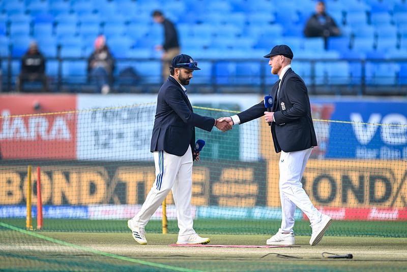 India's captain Rohit Sharma and his England's counterpart Ben Stokes (R) shake hands during the toss before the start of the fifth Test cricket match between India and England at the Himachal Pradesh Cricket Association Stadium in Dharamsala on 7 March, 2024