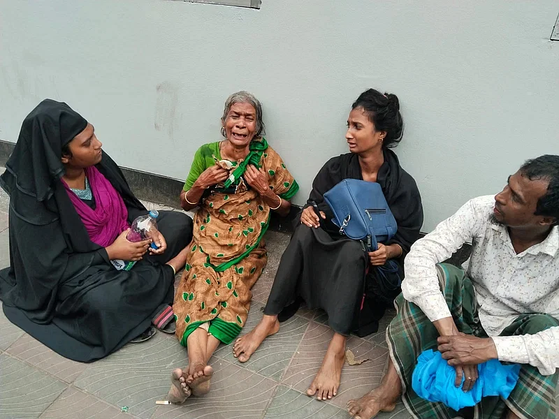 A victim's mother laments on the footpath in front of the Sheikh Hasina National Institute of Burn and Plastic Surgery in Dhaka