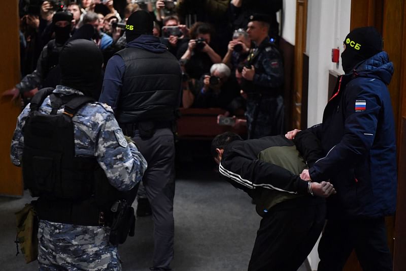 man suspected of taking part in the attack of a concert hall that killed 137 people, the deadliest attack in Europe to have been claimed by the Islamic State jihadist group, is escorted by Russian law enforcement officers prior to his pre-trial detention hearing at the Basmanny District Court in Moscow on March 24, 2024.