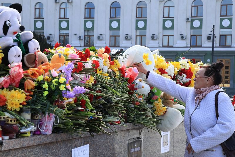 A woman lays flowers at a makeshift memorial in Simferopol, Crimea, on 24 March, 2024, as Russia observes a national day of mourning after a massacre in the Crocus City Hall that killed more than 130 people, the deadliest attack in Europe to have been claimed by the Islamic State (IS) group