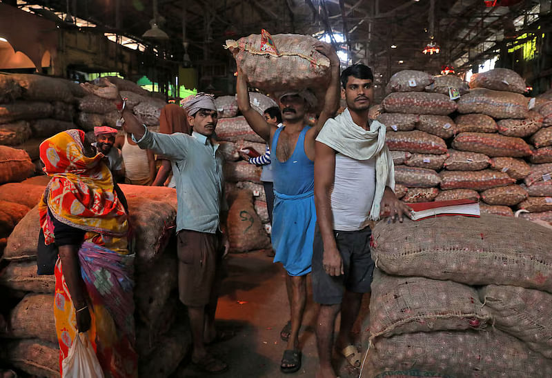 A labourer carries a sack of onions at a wholesale market in Kolkata, India, on 14 December, 2021.