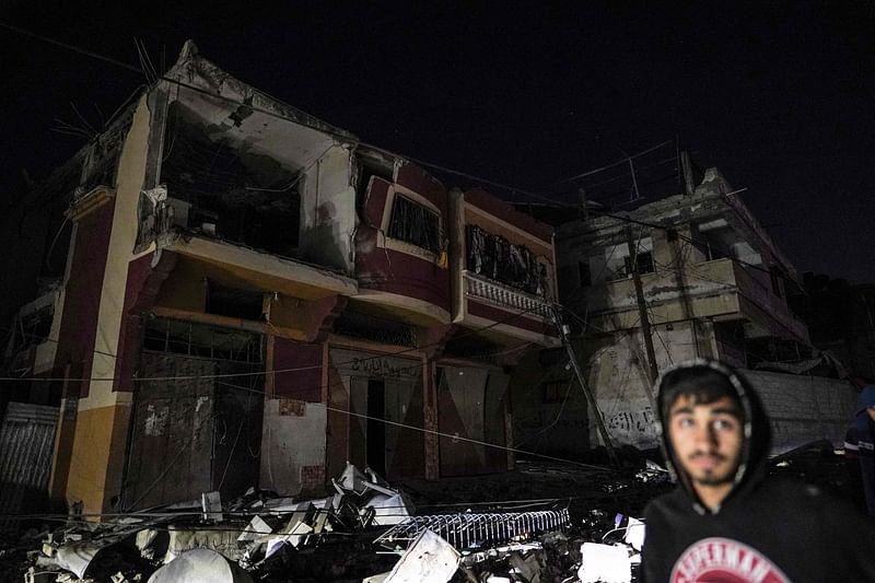 A Palestinian man walks past a house it in Israeli strikes in Zuwayda in the central Gaza Strip on 25 March 2024, amid ongoing battles between Israel and the militant group Hamas.