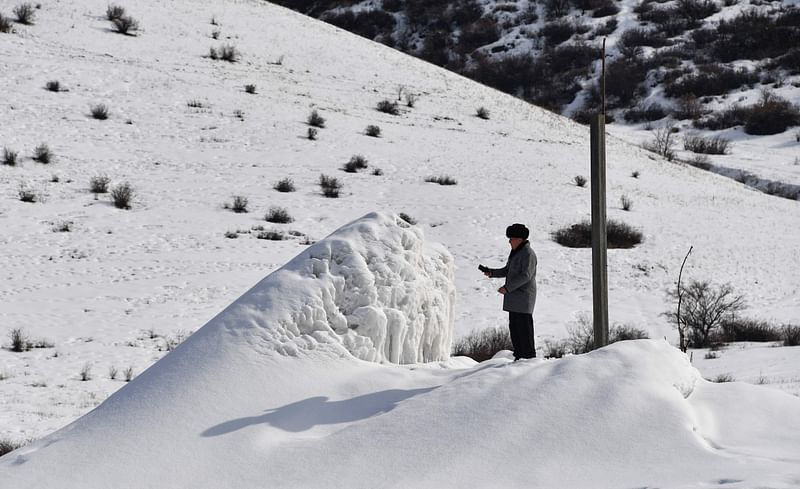 A man is seen at the artificial glacier in a mountain gorge near the village of Syn-Tash, some 60 kms from Bishkek, on 13 February, 2024