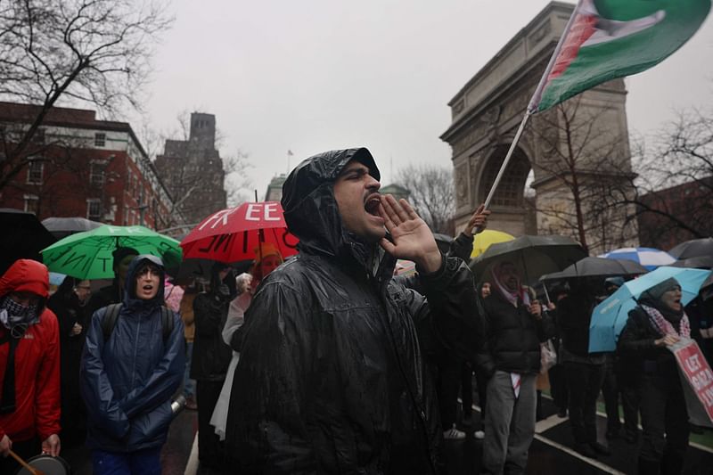 People participate during a rain storm in a demonstration and march to demand that Israel end its war in Gaza and agree to a cease-fire on 2 March, 2024 in New York City. As fighting in Gaza continues, health experts report that over.