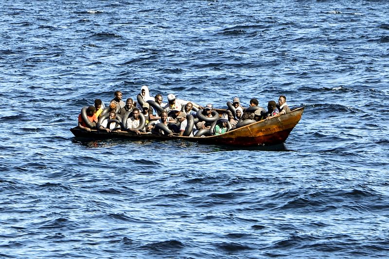 Migrants of African origin trying to flee to Europe are crammed on board of a small boat, as Tunisian coast guards prepare to transfer them onto their vessel, at sea between Tunisia and Italy, on 10 August 2023.