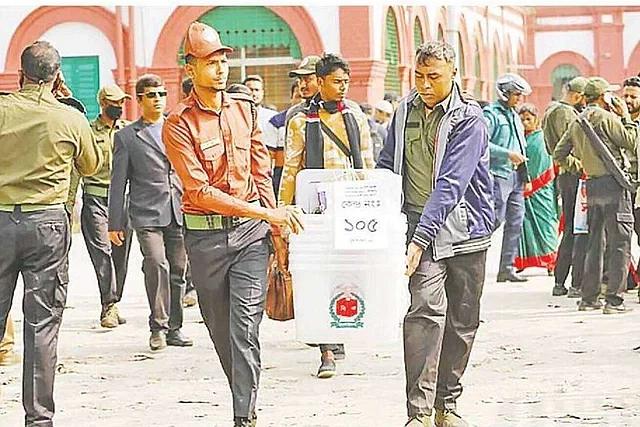 Election officials carry transparent ballot boxes