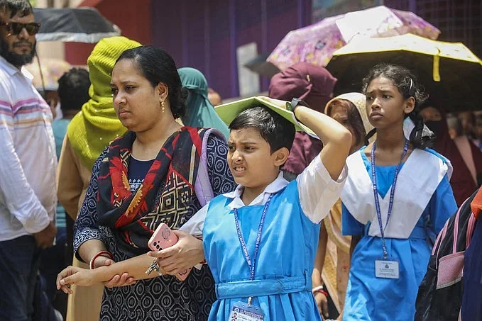 A woman takes her daughter to school amid scorching heat