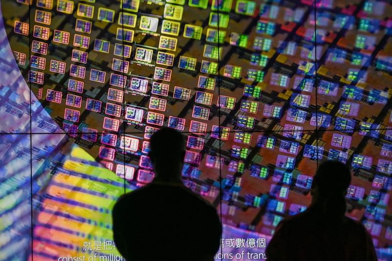 Visitors watch a wafer shown on screens at the Taiwan Semiconductor Manufacturing Company (TSMC) Renovation Museum at the Hsinchu Science Park in Hsinchu on 5 July, 2023