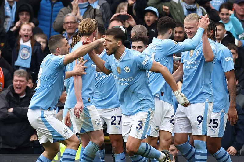 Manchester City's Norwegian striker #09 Erling Haaland (R) celebrates with teammates after scoring their third goal from the penalty spot during the English Premier League football match between Manchester City and Luton Town at the Etihad Stadium in Manchester, north west England, on April 13, 2024.