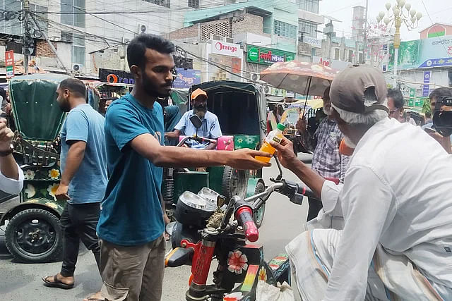 Rajshahi is facing a heat wave. Young members of an organisation, The Smiling Foundation, are distributing free cold drinks to people on the streets to give them some relief in the sweltering summer. Sunday afternoon at Shaheb Bazar Zero Point in Rajshahi city