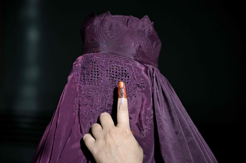 A burqa-clad woman shows her inked finger after casting her ballot to vote in the first phase of India's general election at a polling station in Kairana, Shamli district, in India's Uttar Pradesh state on 19 April 2024.