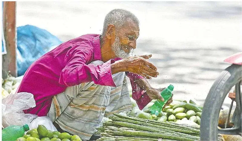 As a very severe heatwave is sweeping over Pabna, vegetables seller Nazim Uddin sprinkles water to cool himself in the Judge Court area of the district on 20 April, 2024