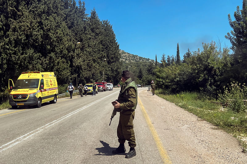 An Israeli soldier looks on at a scene, after it was reported that people were injured, amid ongoing cross-border hostilities between Hezbollah and Israeli forces, near Arab al-Aramashe in northern Israel on 17 April, 2024