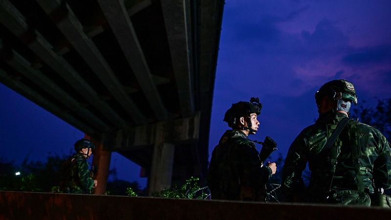 Thai military personnel stand guard overlooking the Moei river on the Thai side, near the Tak border checkpoint with Myanmar, in Thailand's Mae Sot district on 10 April, 2024