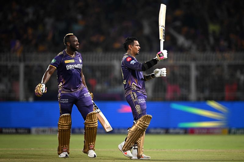 Kolkata Knight Riders’ Sunil Narine (R) celebrates after scoring a century (100 runs) as his teammate Andre Russell watches during the Indian Premier League (IPL) Twenty20 cricket match between Kolkata Knight Riders and Rajasthan Royals at the Eden Gardens in Kolkata on 16 April, 2024