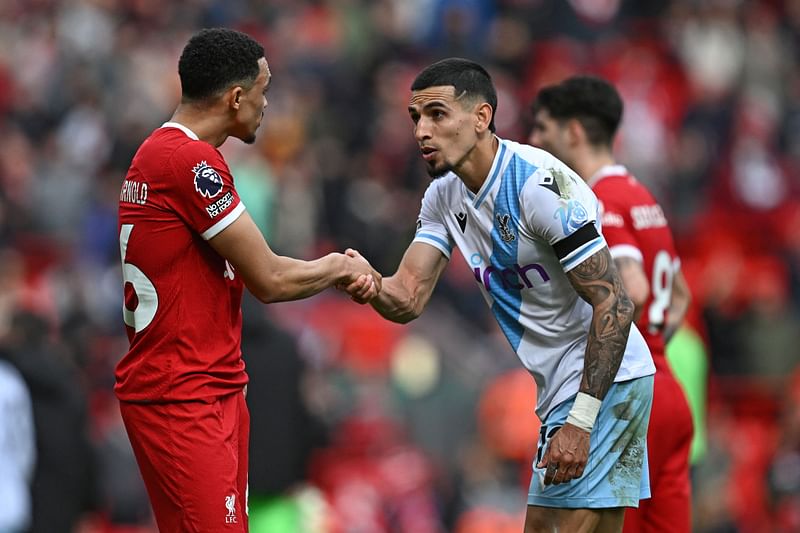 Crystal Palace’s Colombian defender #12 Daniel Munoz (R) shakes hands with Liverpool’s English defender #66 Trent Alexander-Arnold (L) on the pitch after the English Premier League football match between Liverpool and Crystal Palace at Anfield in Liverpool, north west England on 14 April, 2024