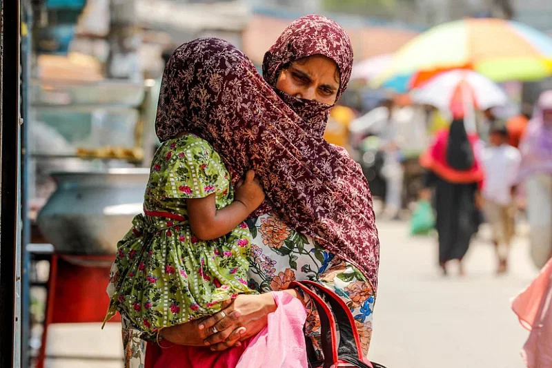 A mother protects her child from the scorching heat with her scarf. Photo taken from Sonadanga Bou bazar area in Khulna city on 26 April.