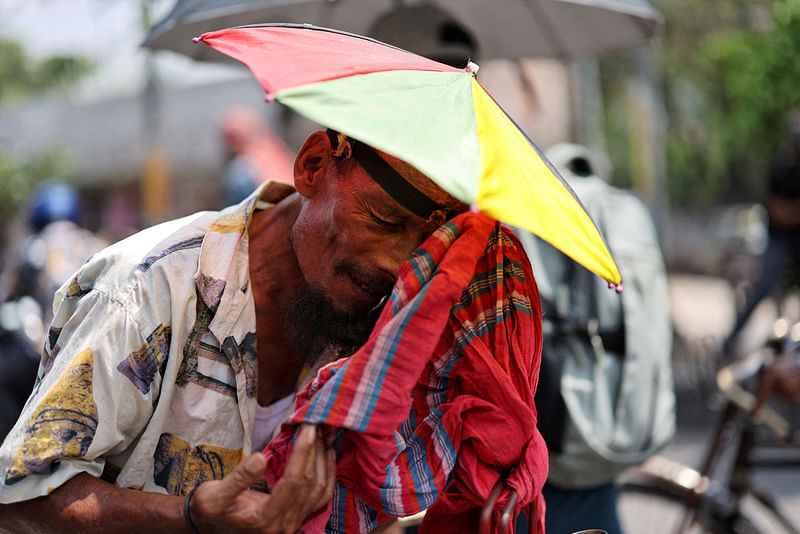 A rickshaw puller wipes sweat with a scarf during the countrywide heatwave in Dhaka, Bangladesh, on 22 April, 2024