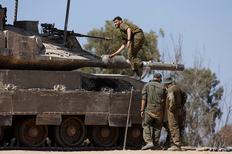 Israeli soldiers stand next to a tank, near the Israel-Gaza border, amid the ongoing conflict between Israel and the Palestinian Islamist group Hamas, in Israel, 15 April, 2024.