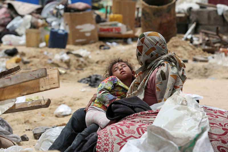 A child rests on the day Palestinians travel on foot along with their belongings, as they flee Rafah due to an Israeli military operation, in Rafah, in the southern Gaza Strip, on 28 May, 2024