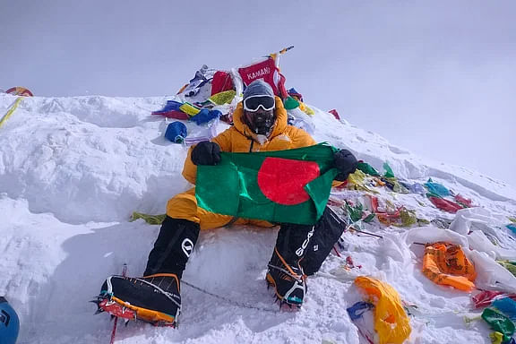 Babar Ali poses with the national flag on Mount Everest.